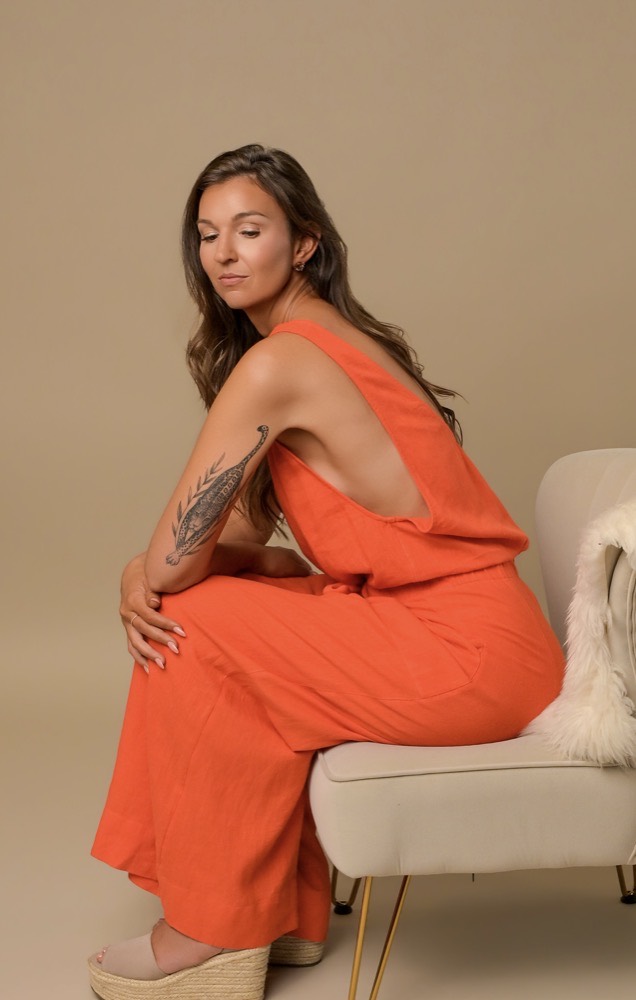 Rebecca in terracotta linen, seated in contemplation